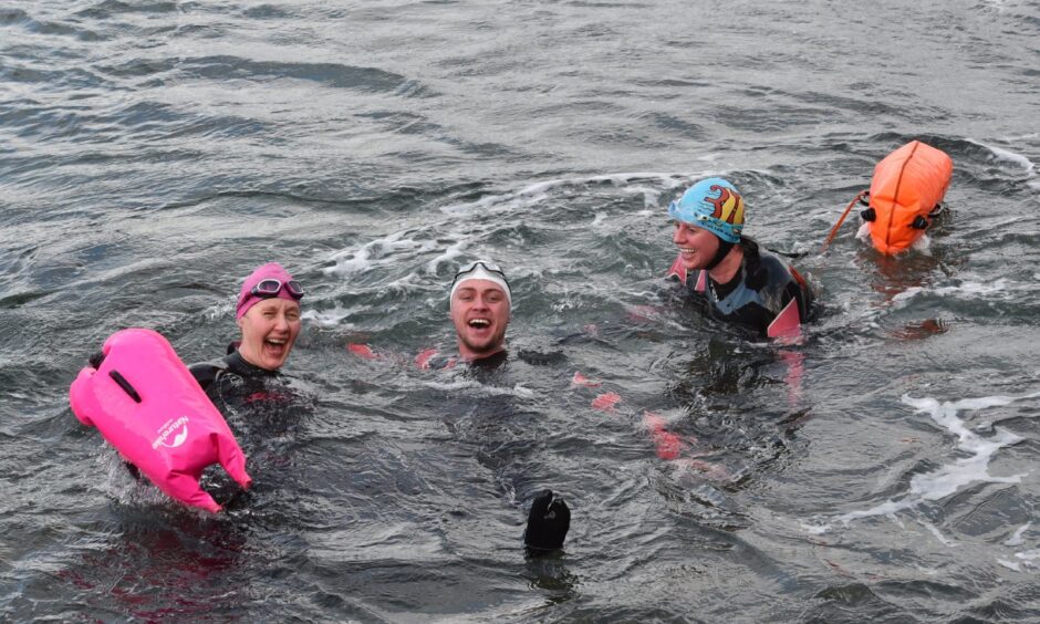 Some of the swimmers in the water laughing who braved the North Sea, swimming over a mile from the Macduff Aquarium to Tarlair outdoor pool to raise money for the Tarlair pool.
