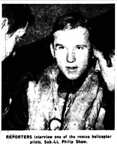 A newspaper clipping with a photograph of a man and the caption 'reporters interview one of the rescue helicopter pilots, Sub Lt Phillip Shaw.'