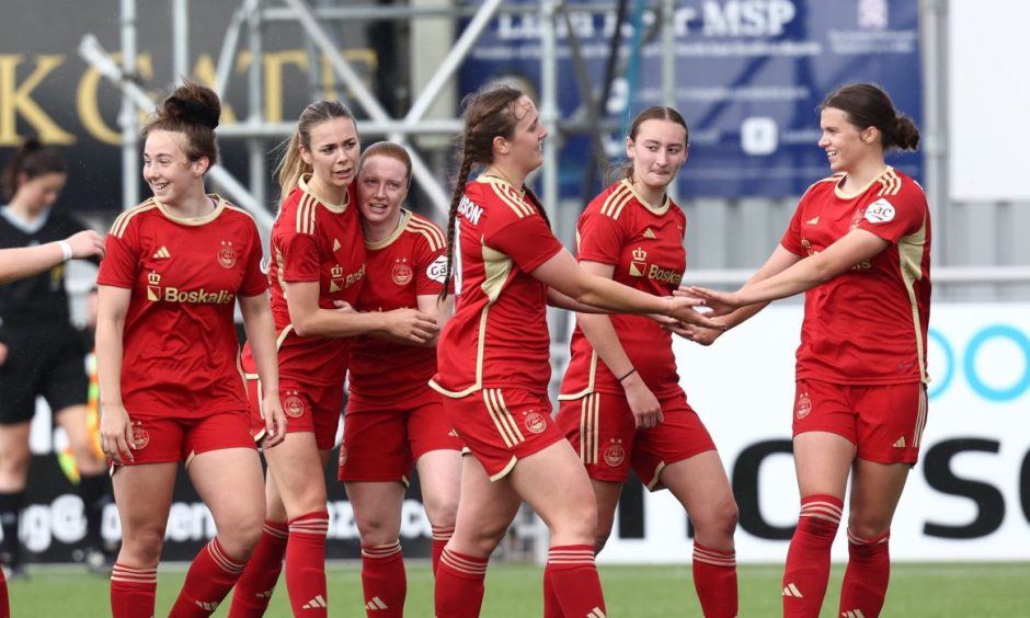 Aberdeen Women players celebrate scoring in a match.