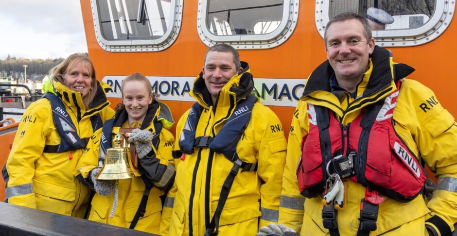 Emma Cato receives her commemorative ships bell from crewmember Donald Matheson with Dad Glenn and Mum Rachel.