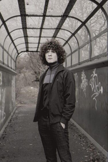 Dylan on a covered, graffitied bridge