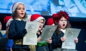 Children singing in festive hats