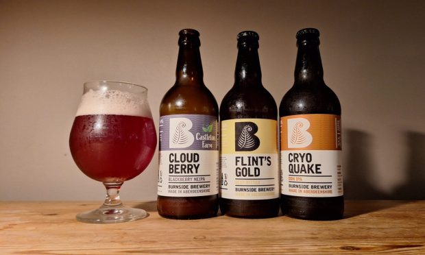 Three bottles of Burnside Brewery Beer, with one red coloured beer poured out into a glass.