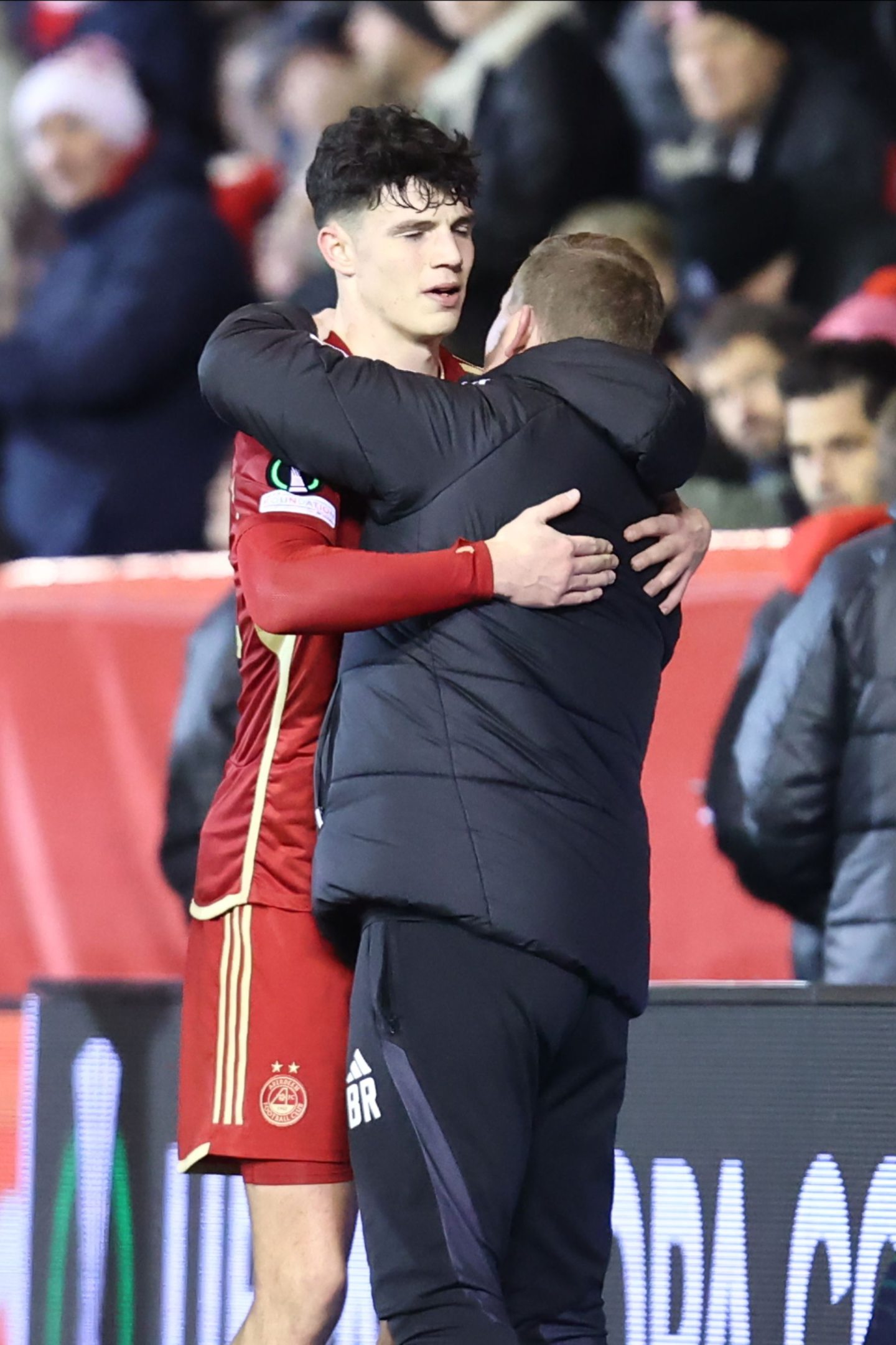Aberdeen defender Jack Milne is embraced by boss Barry Robson after the Eintracht Frankfurt game at Pittodrie Stadium. Image: Shutterstock