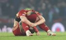 Aberdeen defender Slobodan Rubezic sitting on the pitch with his head between his knees and his shirt covering his face