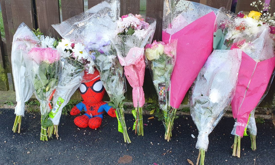 Spiderman doll among floral tributes. 