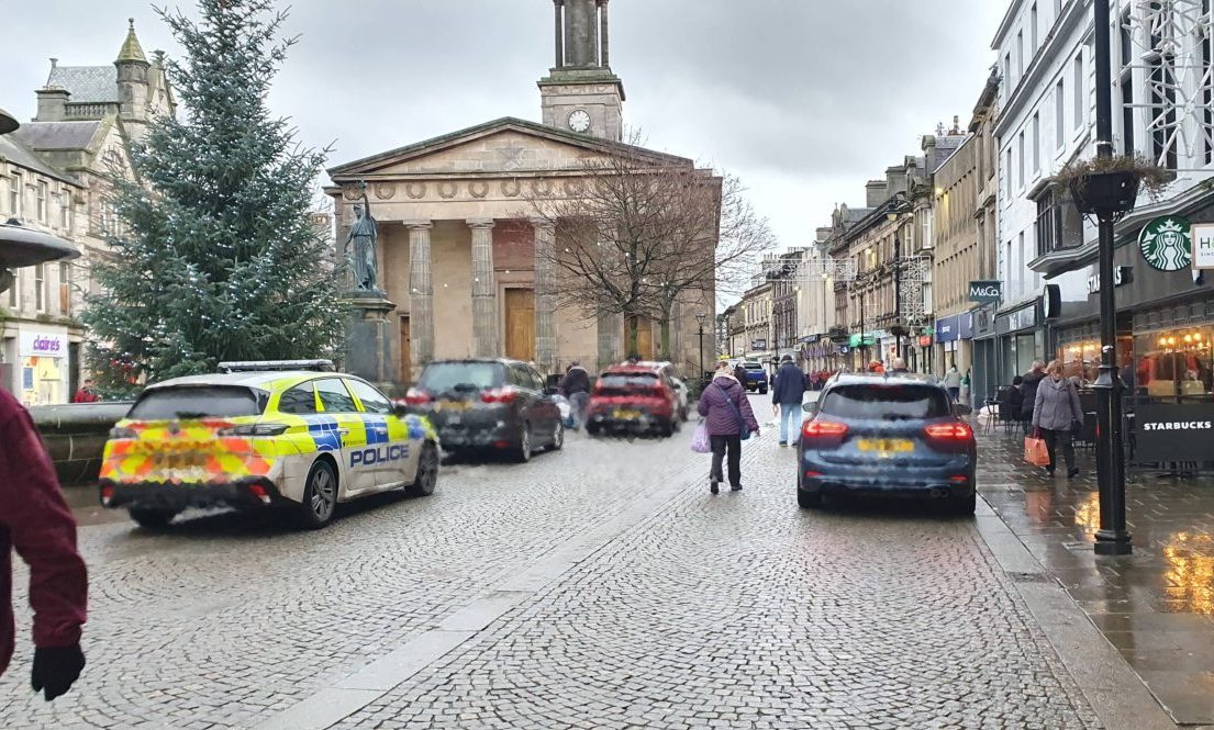 Elgin High Street busy with parked cars. 