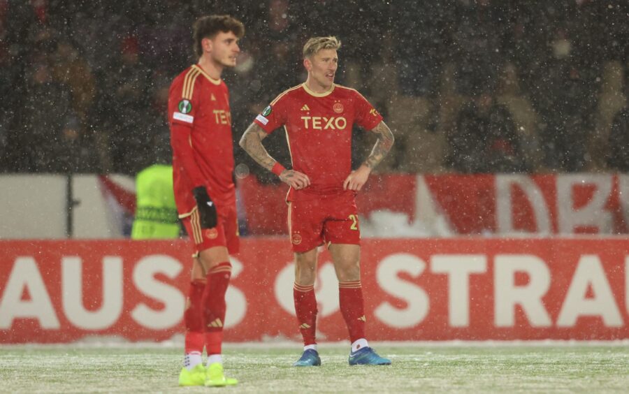 Aberdeen's Angus MacDonald (right) is dejected after Santeri Hostikka scores to make it 2-0 HJK Helsinki in Finland. Image: SNS.