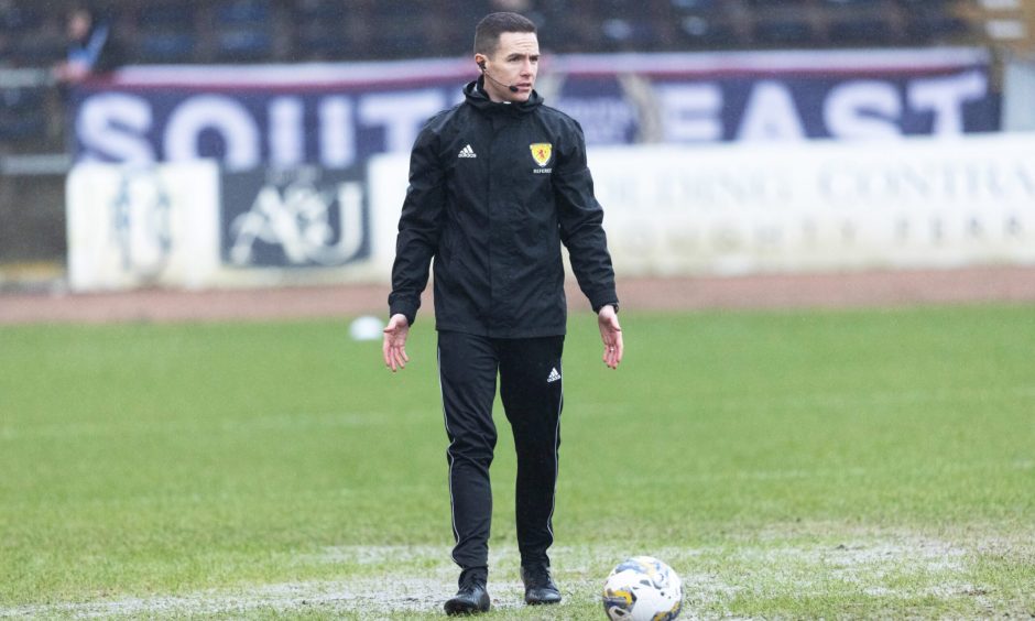 Referee David Munro conducts a pitch inspection before calling off Aberdeen's game with Dundee at Dens Park. Image: SNS