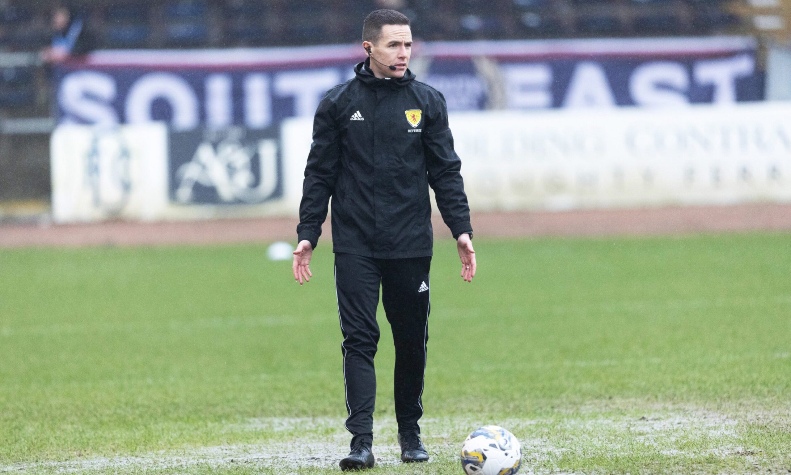Referee David Munro conducts a pitch inspection before calling off Aberdeen's game with Dundee at Dens Park. Image: SNS