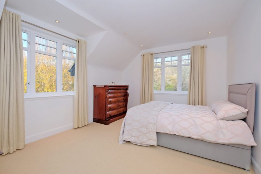 One of the bedrooms in the property with a double bed and dark wood dresser