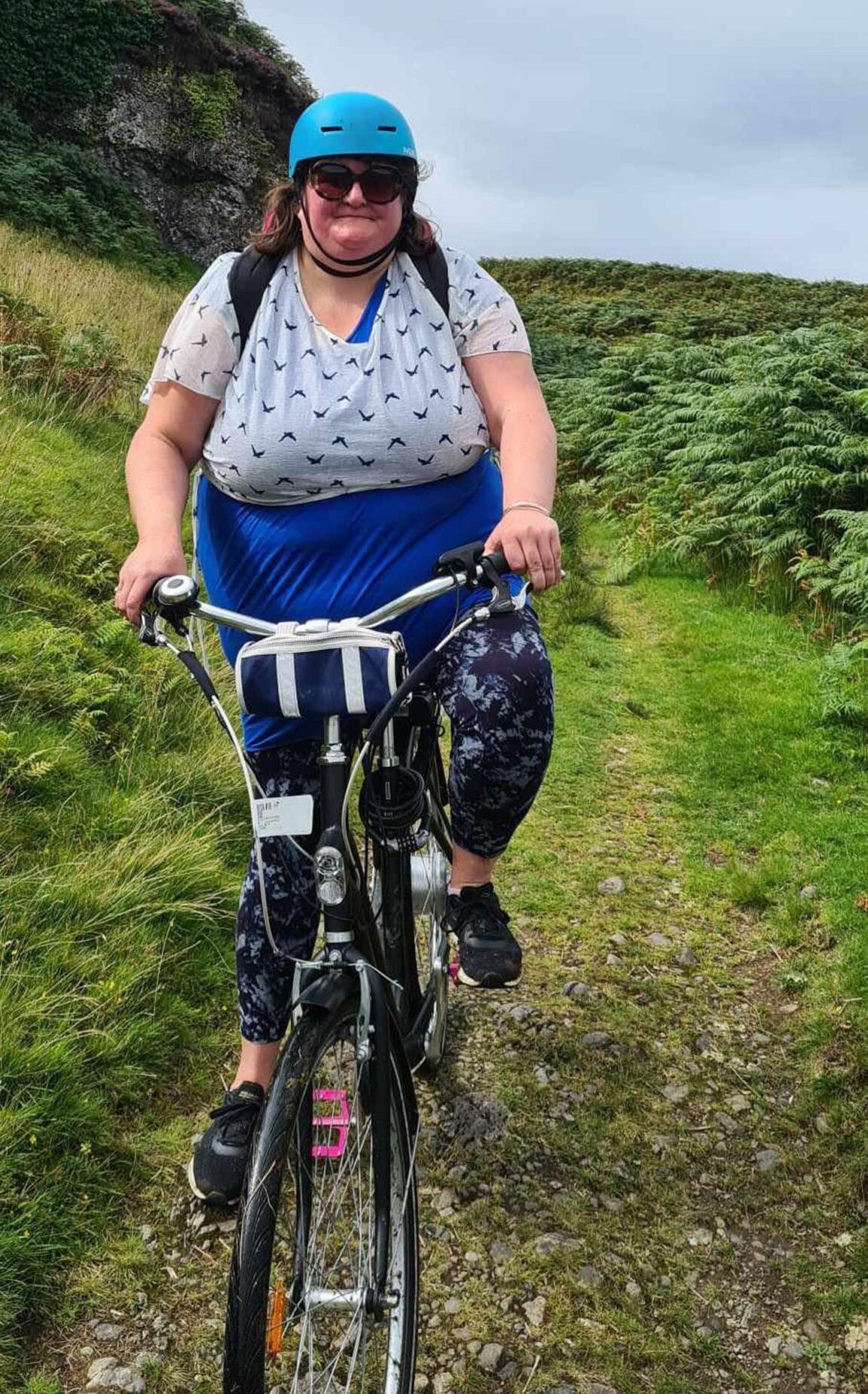 Louise Glen cycling up a hill on a bike. 