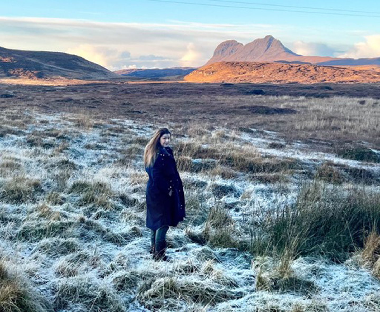 Beth in the snow with the Scottish countryside behind her