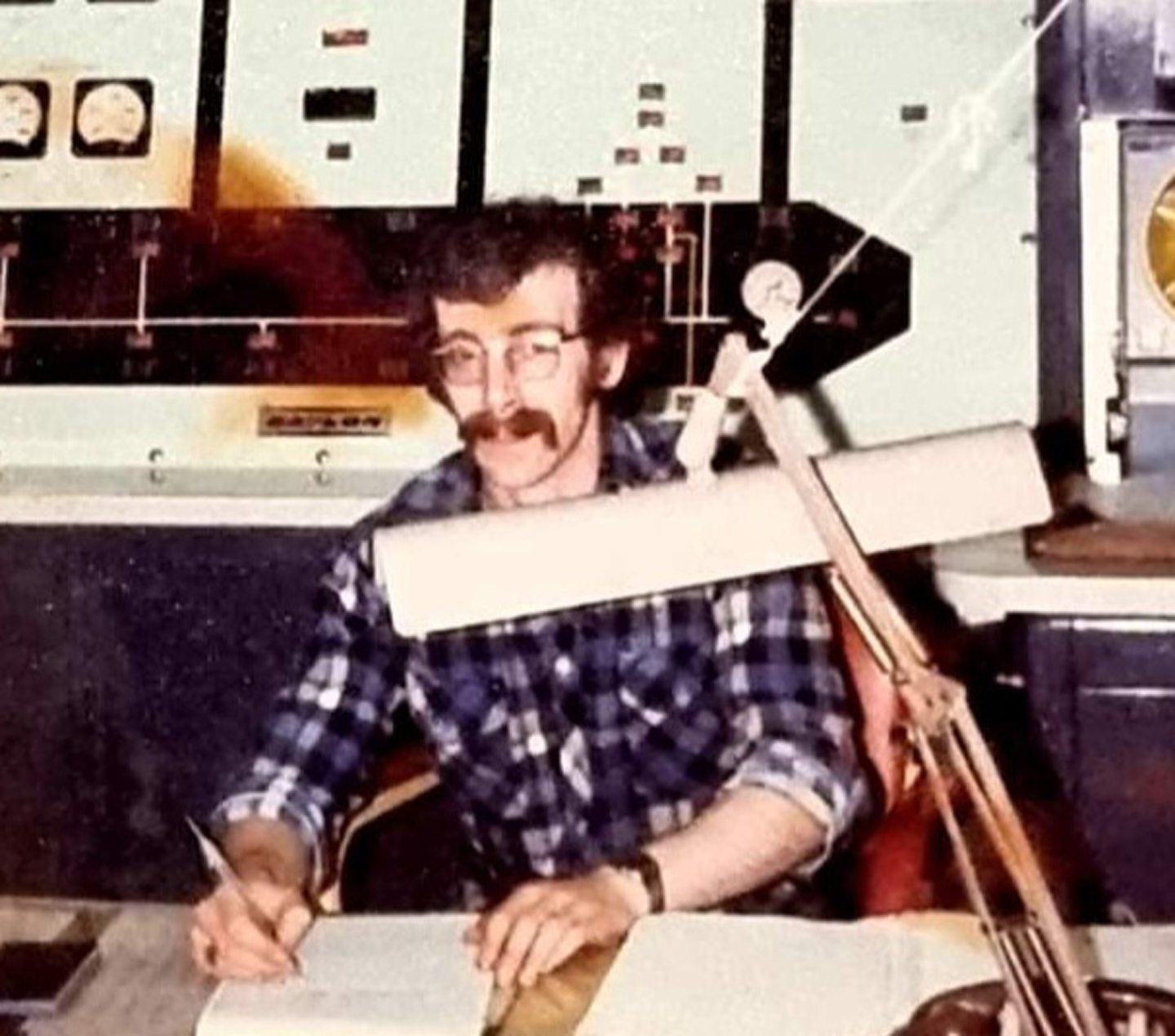 Colin Adamson working at a desk in an old photograph. 