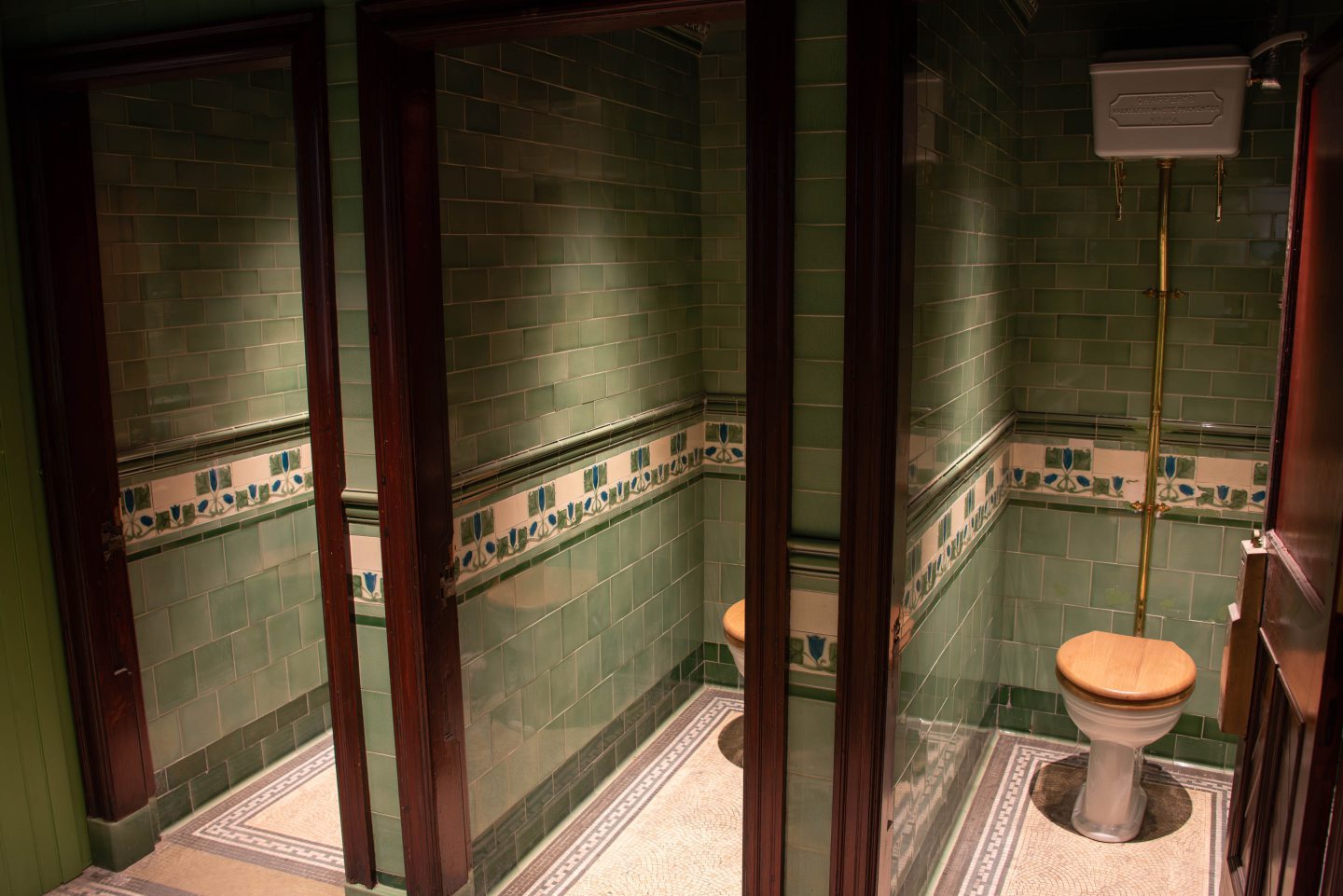 Cubicles in the toilets at Union Square Gardens with intricate wall and floor tiling.