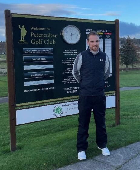 Callum Stewart standing in front of a sign for Peterculter Golf Club