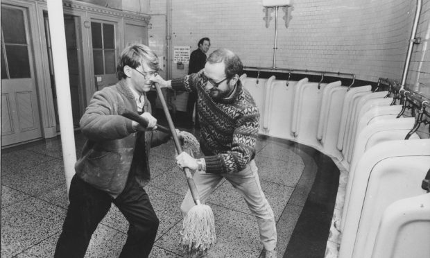 Antique dealers John Semple of Kent-Strip Antiques and John Somerville of Turrett Antiques slug it out over who should have the pick of this fine Victorian convenience in Castlegate, as an unsuspecting man at the urinal looks on. Image: DC Thomson
24 September 1985