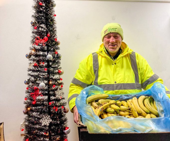 Volunteer for the charity in Aberdeen with box of bananas.