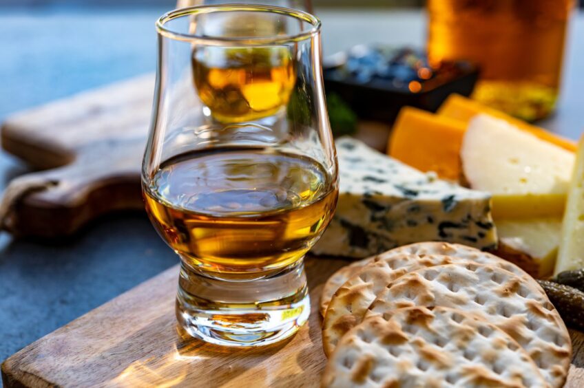 Glass of whisky and cheese platter