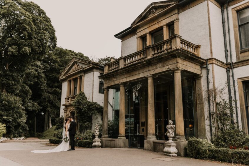 Couple standing at front of Norwood Hall