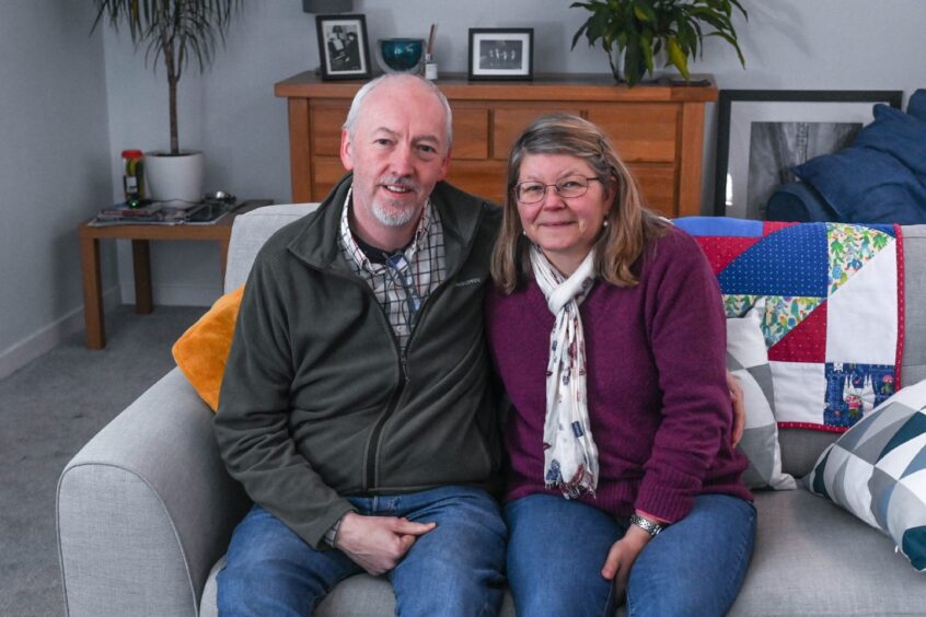 Garry and Anne Barclay sitting on a sofa.