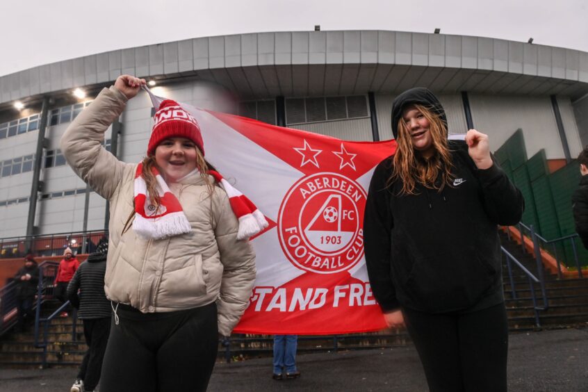 Young Dons fans hold flag outside the stadium.
