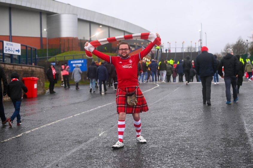 Aberdeen fans dressed in all Dons colours, complete with red tartan kilt and well as red and white socks and scarf.