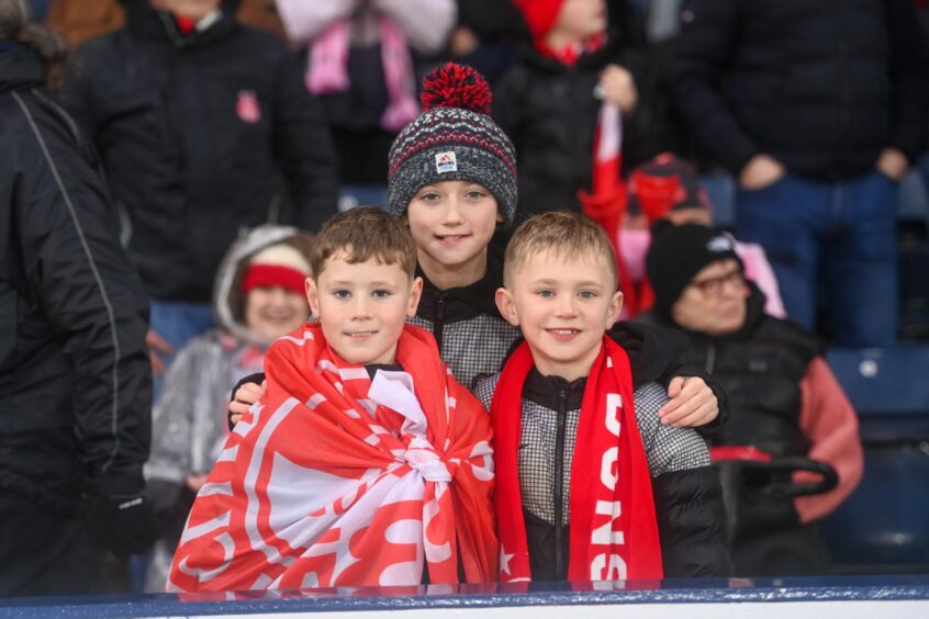 Young Dons fans pose for a photo in the stand.