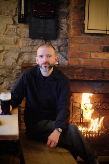 David Murphy with a fireplace behind him