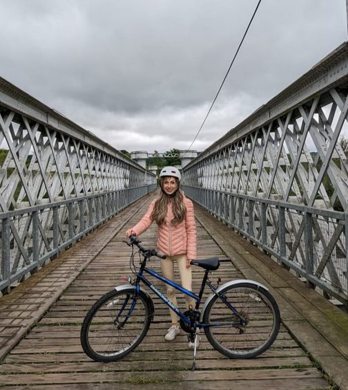 Katie Cunningham and her bike on a bridge