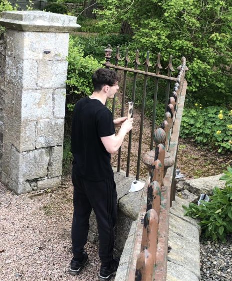 Tony Eddison's son James working on restoring the fence outside