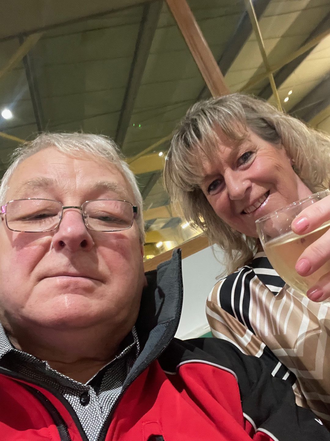 A selfie photo of Tommy and Margaret holding a glass of wine