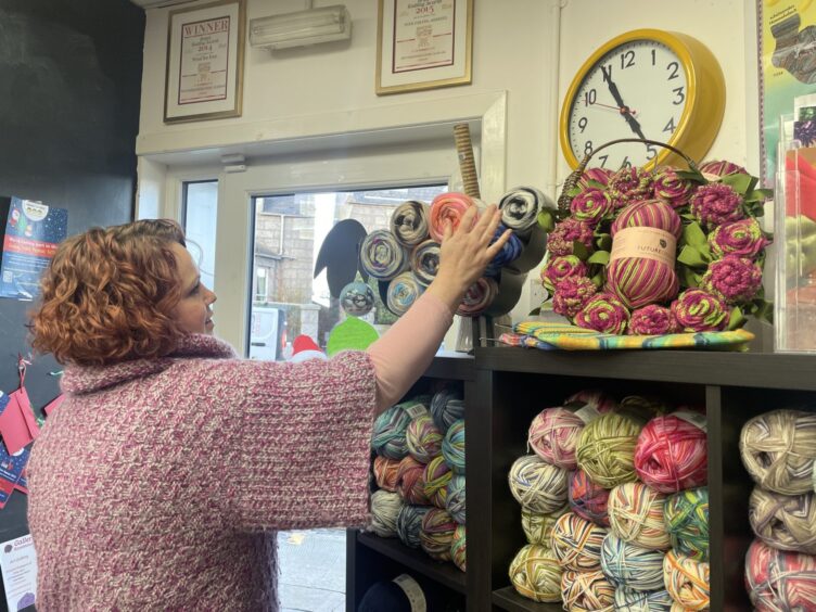 Faye Howard putting away balls of wool at Wool for Ewe.