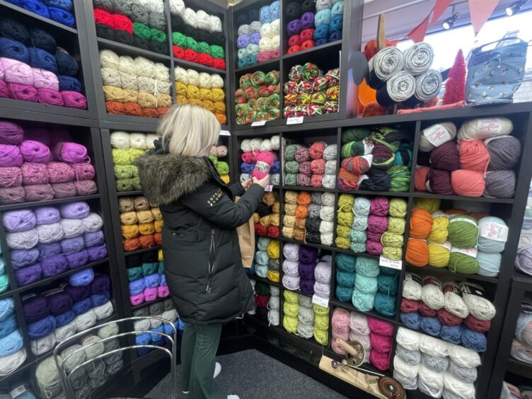 A customer browses for knitting supplies at Wool for Ewe in Aberdeen.