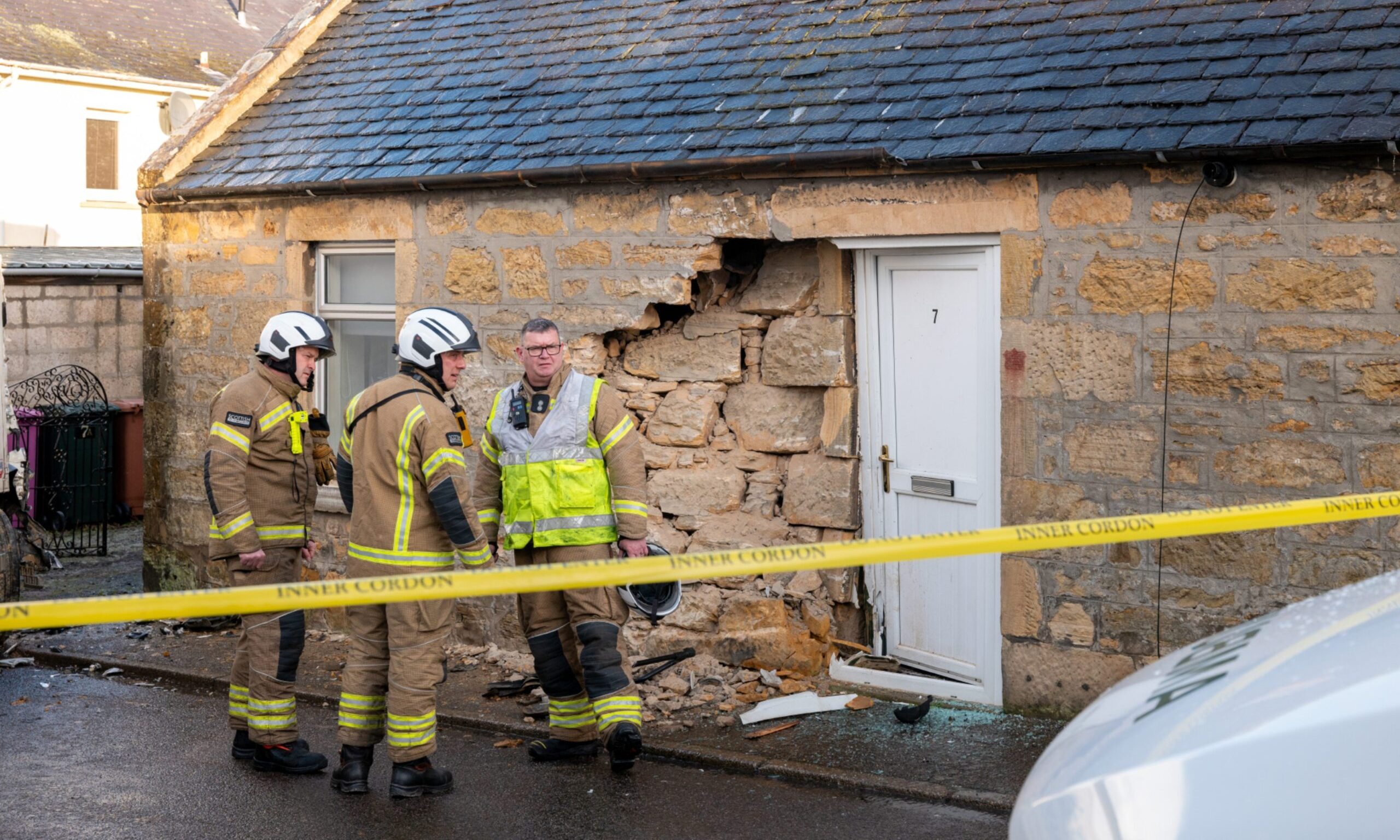 Fireman outside home that has been hit by lorry. 