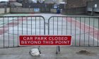 Gates across car park with sign saying "car park closed beyond this point".