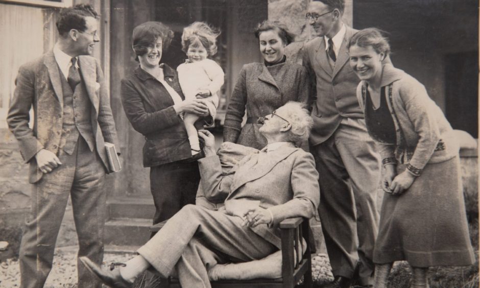 Ramsay MacDonald in a chair surrounded by his family.