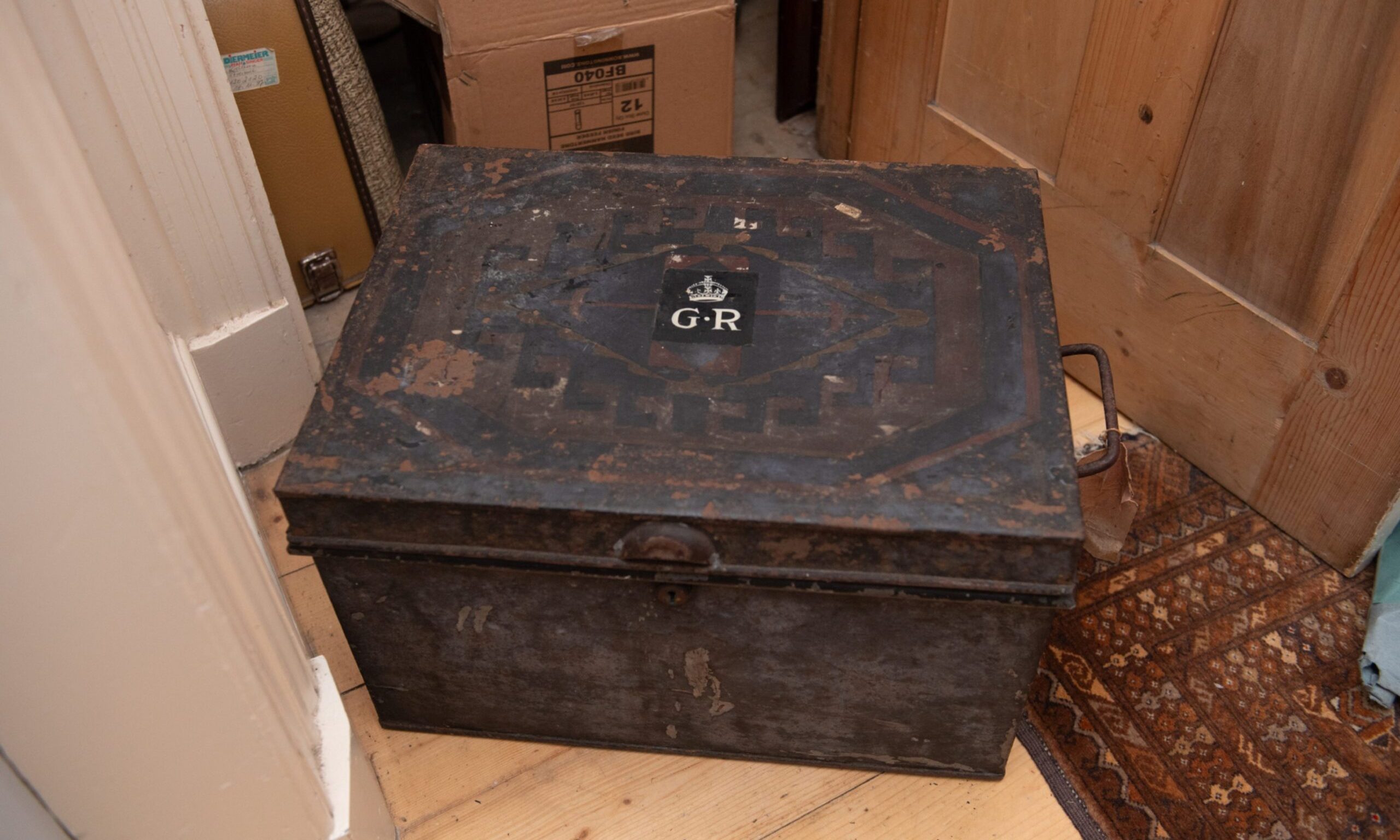 Black despatch box on ground with GR insignia on top. 