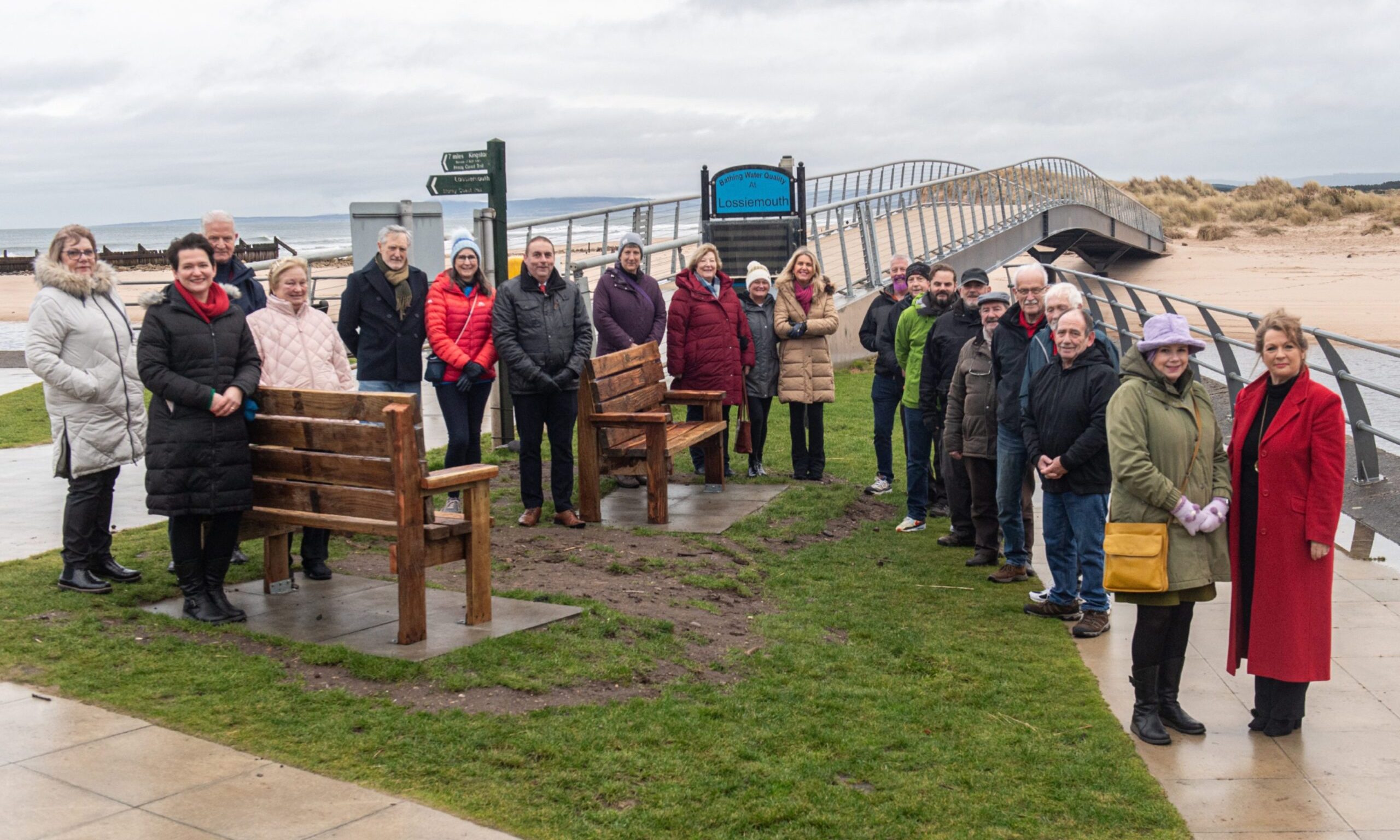 Community representatives surrounding new benches at Lossiemouth beach.