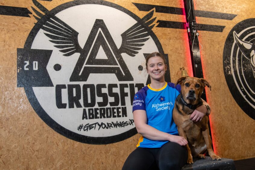 Aine Gillespie hugs the CrossFit Aberdeen dog Bella.