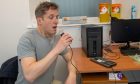 Andy Morton, P&J's health reporter, blows into a spirometer to test his lung power at his offshore worker medical in Aberdeen.
