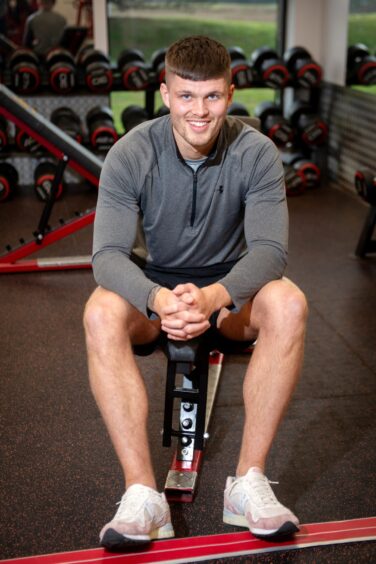 Personal trainer james sitting on equipment in Westhill's Colosseum gym