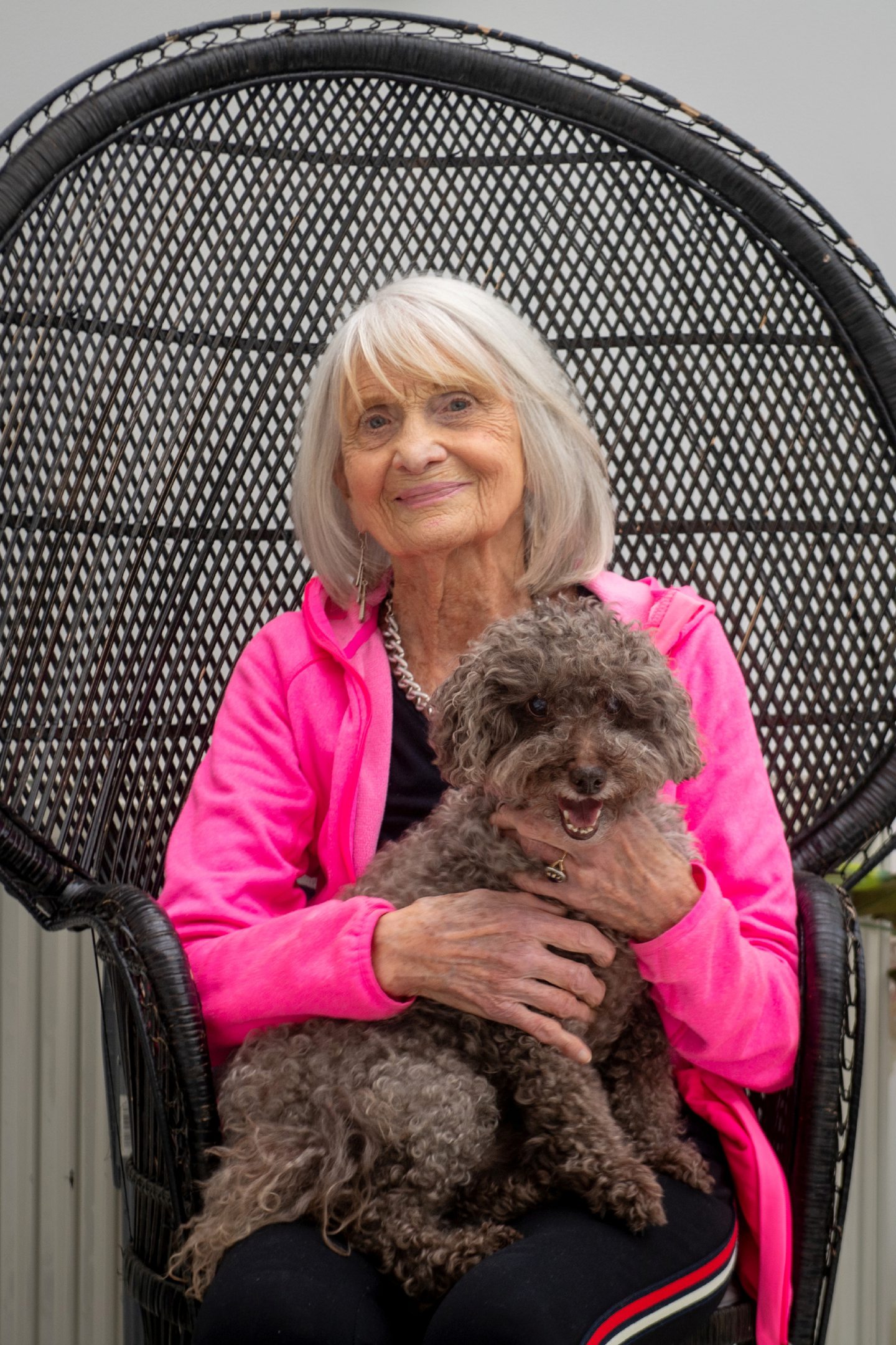Jeane with her dog on a wicker chair