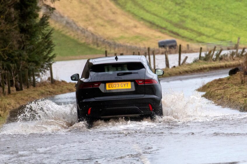 Car driving through floods.