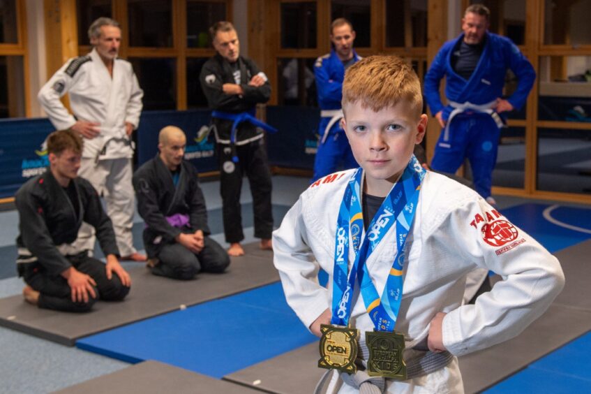 Dexter Richardson with his two medals in front of the BJJ class. 