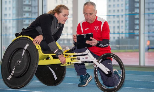 Aberdeen Amateur Athletic Club coach Phil Owens at Aberdeen Sports Village's indoor athletics track working with his star athlete, wheelchair ace Joanna Robertson. Image: Kami Thomson/DC Thomson.