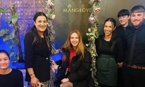 Karen Gillan sits on a swing covered in flowers alongside staff at Mangrove in Inverness.