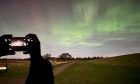Person taking photo of Northern lights at Culloden battlefield