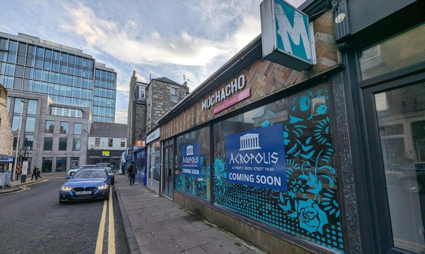 Acropolis banners in the window of Muchacho on Rose Street.