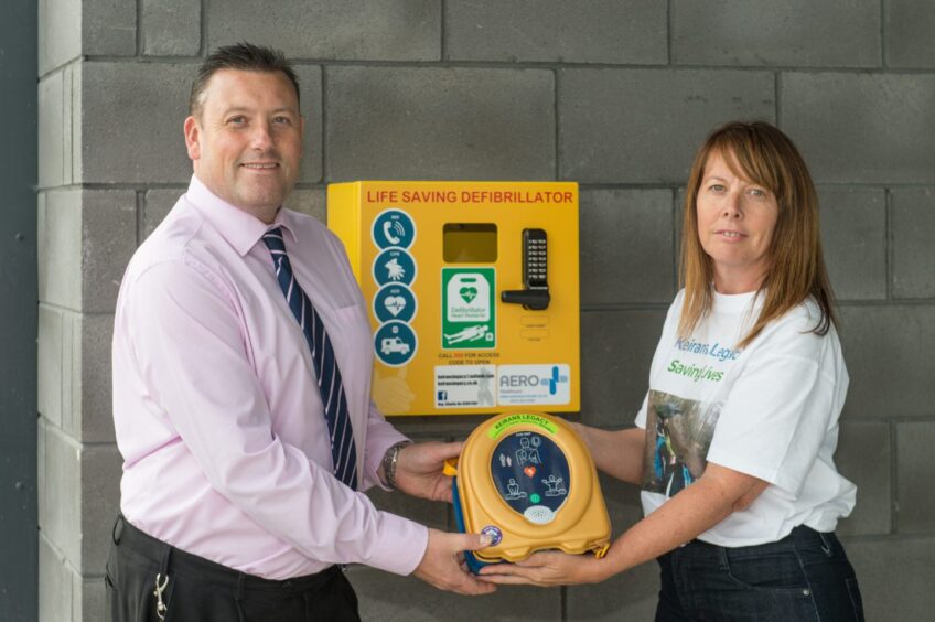 Hugh McCulloch, headteacher of Elgin High School, and Sandra McKandie, from Keiran's Legacy, with the defibrillator at Elgin High School